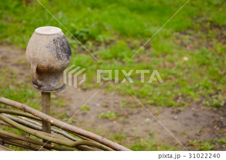Brown clay pot on a wicker fence. Brown clay pot on a wicker fence. 31022240