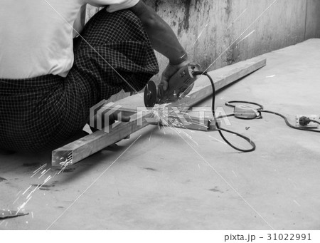 WORKER CUTTING STEEL WITH ELECTRIC WHEEL GRINDER 31022991