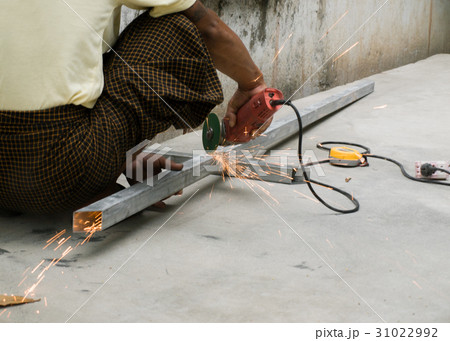 WORKER CUTTING STEEL WITH ELECTRIC WHEEL GRINDER 31022992
