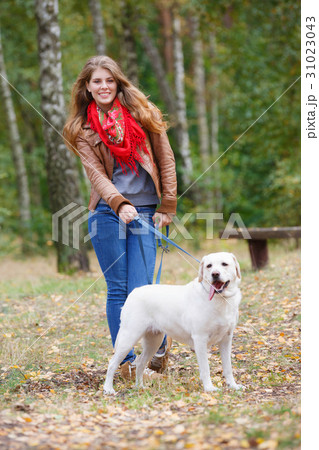 Beautiful woman walking with her dog in the forest Beautiful woman walking with her dog in the forest 31023043