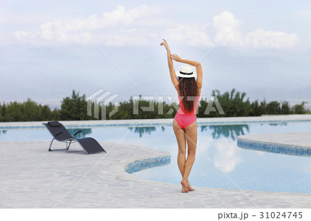 Beautiful female model posing by the outdoor pool 31024745