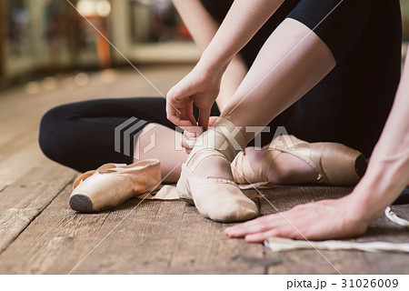 Ballerina putting on her ballet shoes 31026009