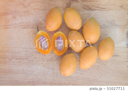 Cleaved marian plum on wooden texture background 31027711