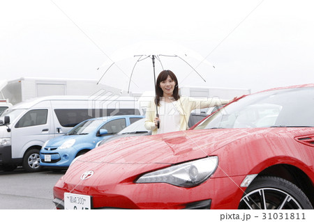 スポーツカーに乗り込む女性の写真素材