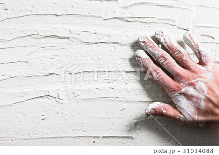 Worker hand on stucco wall. Building background. 31034088