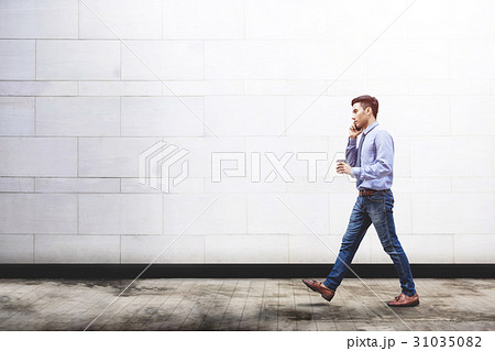 Businessman talk via smart phone while walk 31035082