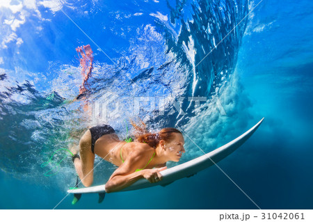 Active girl in bikini in dive action on surf board 31042061
