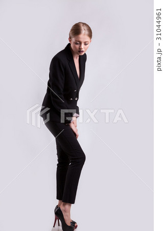 Styled sensual blonde in fashion suit on gray 31044961