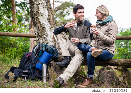 Couple on hike taking rest under tree  31050581