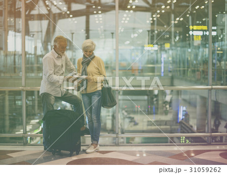 Senior adult couple with traveling luggage at airport Senior adult couple with traveling luggage at airport 31059262