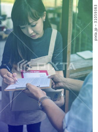 Young woman receive a parcel and sign the document Young woman receive a parcel and sign the document 31059363