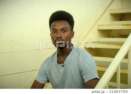 young man sitting in the stairs concrete wall young man sitting in the stairs concrete wall 31063700