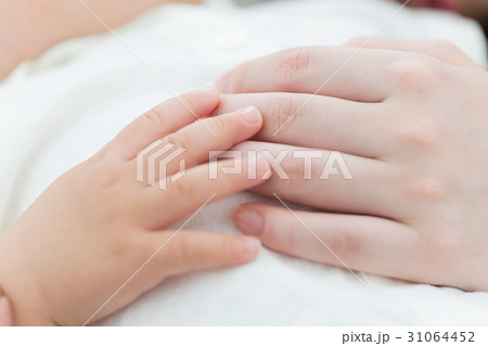 寄り添う赤ちゃんとお母さんの手の写真素材