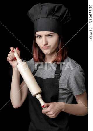 Young attractive woman chef in black uniform holds 31067350