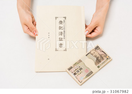 不動産受渡証書に契約して現金の手付金を支払う日本人の女性の写真素材 