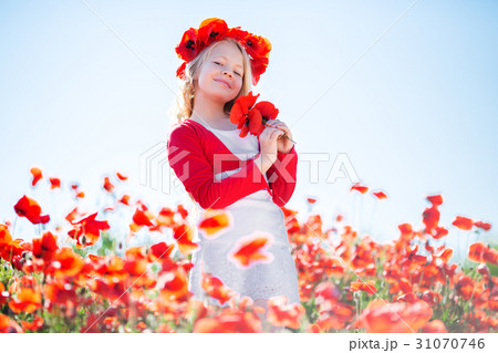Happy blonde child girl in poppy field 31070746