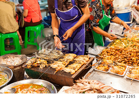 Man cooks prawns on the grill 31072265