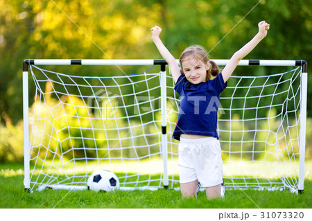 Cute little girl having fun playing a soccer game Cute little girl having fun playing a soccer game 31073320
