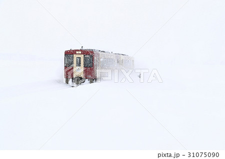 吹雪の中を走る飯山線観光列車 おいこっと の写真素材