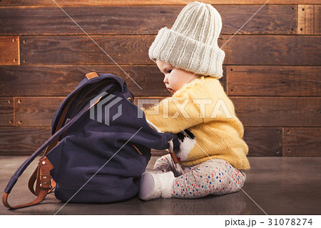Cute baby with backpack on wooden background 31078274