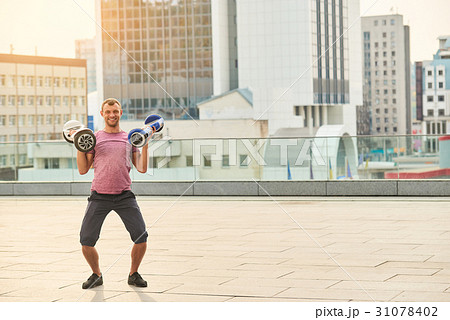 Man holding two hoverboards. Man holding two hoverboards. 31078402