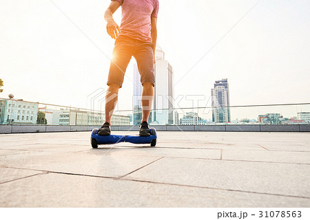 Man riding hoverboard, city. 31078563