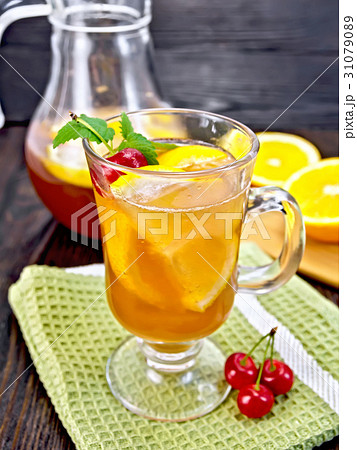 Lemonade with cherries in wineglass and jug 31079089