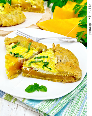 Pie of pumpkin and basil in plate on light board 31079118