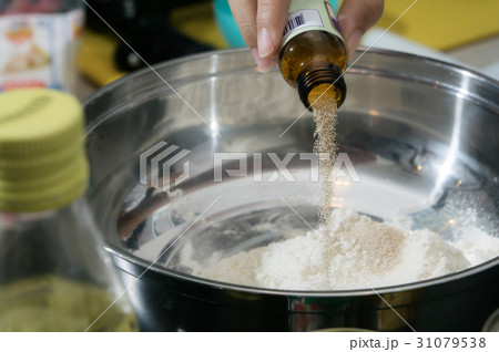pouring some yeast in to the stainleass blow 31079538