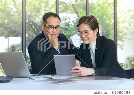 Business persons discussing and working together Business persons discussing and working together 31080593