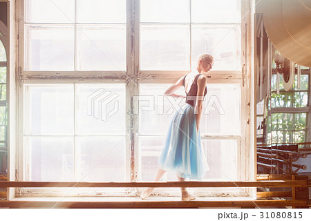 Ballerina is dancing in front of a large window 31080815