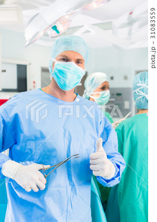 Hospital surgeons operating in operation room 31083559