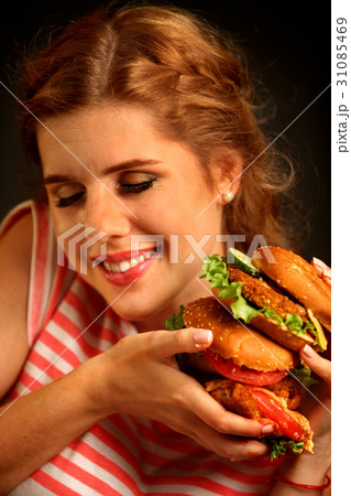 Woman eating burger and winks. Happy student eat 31085469