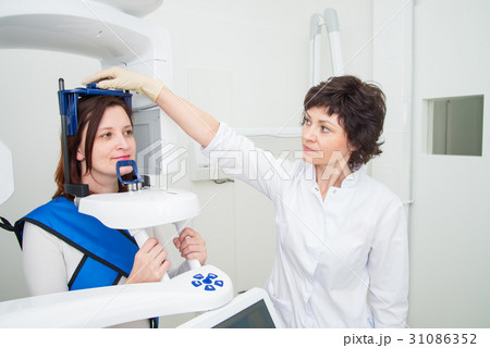 Dentist taking a panoramic digital X-ray of a Dentist taking a panoramic digital X-ray of a 31086352