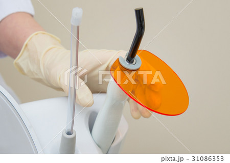 Nurse holding Dental UV curing light lamp 31086353