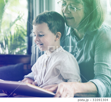 Grandmother and little cute grandson reading book together Grandmother and little cute grandson reading book together 31091304