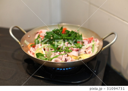 Happy housewife cooking squid with seafood in home Happy housewife cooking squid with seafood in home 31094731