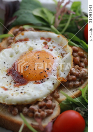 目玉焼きを乗せた納豆トーストと野菜サラダ 31095645