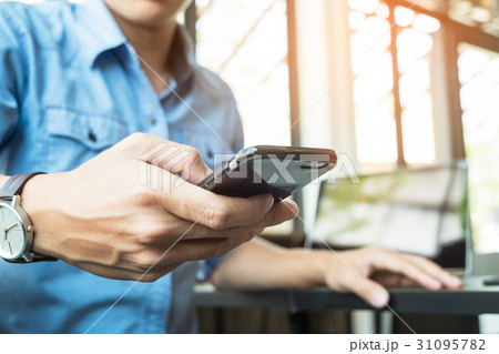 Smiling young casual business man with mobile phone in the hand Smiling young casual business man with mobile phone in the hand 31095782