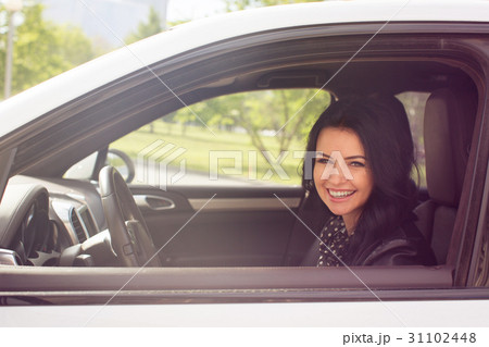 A woman smiles and looks into the camera in car A woman smiles and looks into the camera in car 31102448