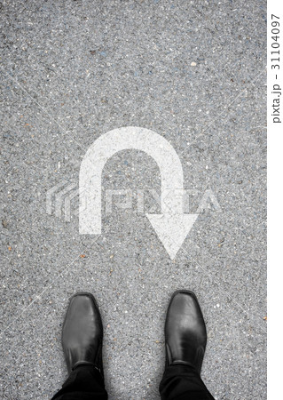 Black shoes standing in front of u turn symbol 31104097
