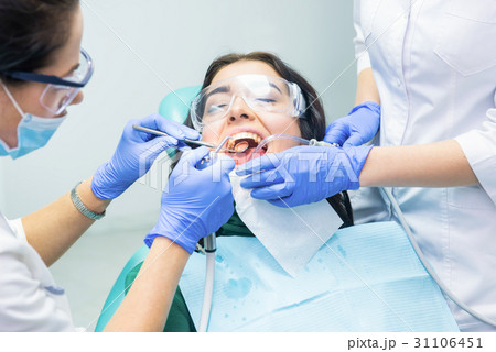 Dentists busy with patient. 31106451