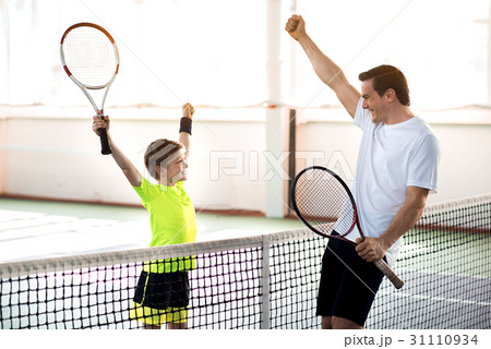Happy parent and child having fun on tennis court Happy parent and child having fun on tennis court 31110934