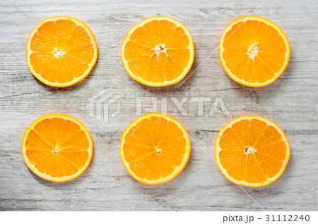 Six slices of fresh oranges on white wood 31112240
