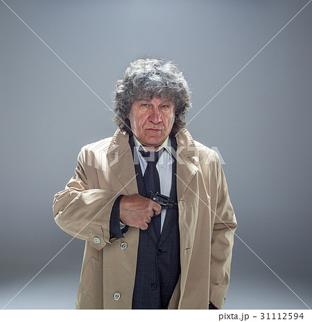 Senior police agent with a gun on studio 31112594