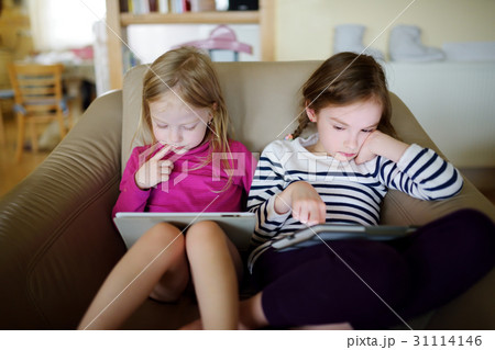 Two little sisters having fun using digital tablet 31114146