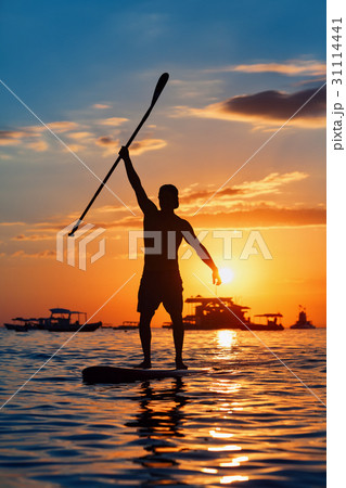 Black silhouette of paddle boarder standing on SUP 31114441
