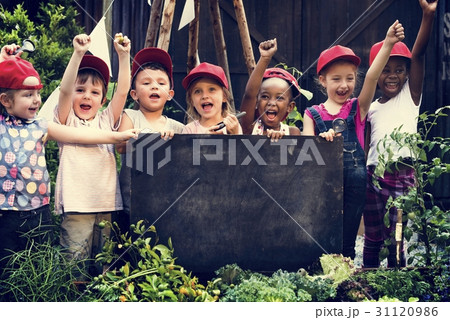 Group of children holding blank blackboard in garden Group of children holding blank blackboard in garden 31120986