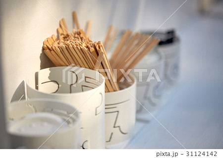 wooden drink stirrers in holder on table 31124142