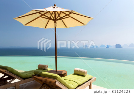 infinity pool with parasol and sun beds at ocean 31124223